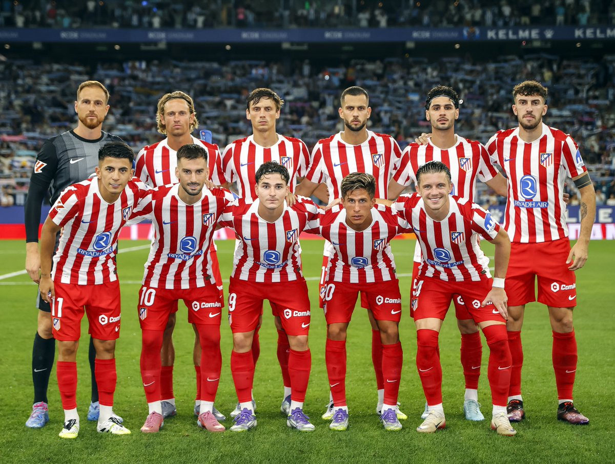 Atlético Madrid players stand together before a match
