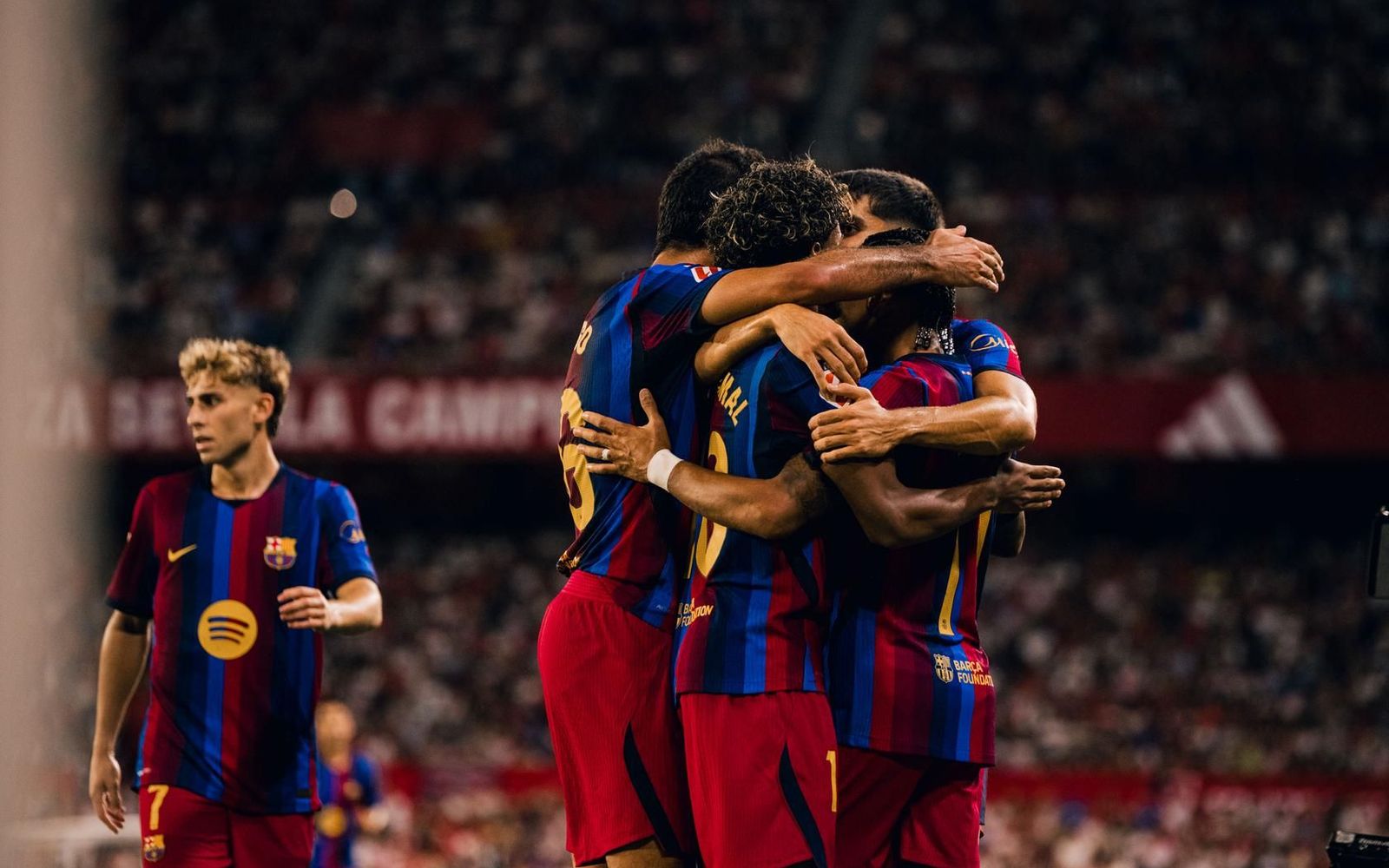 Barcelona players embrace in celebration during the win over Sevilla