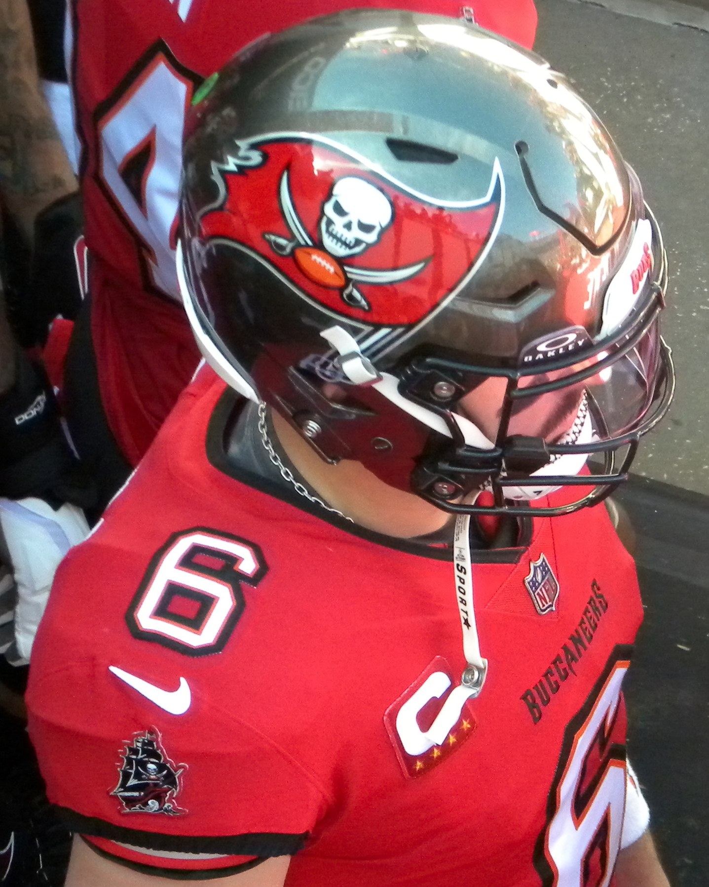 Baker Mayfield in a red Tampa Bay Buccaneers jersey and helmet on the sideline