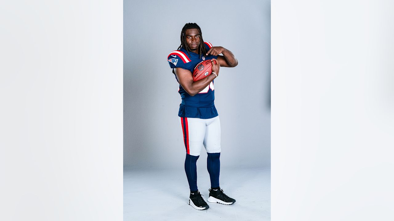 Rhamondre Stevenson poses with a football in his New England Patriots uniform