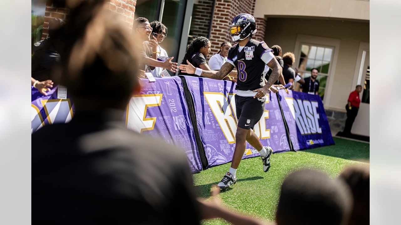Lamar Jackson greets fans as he enters the Ravens training camp practice field