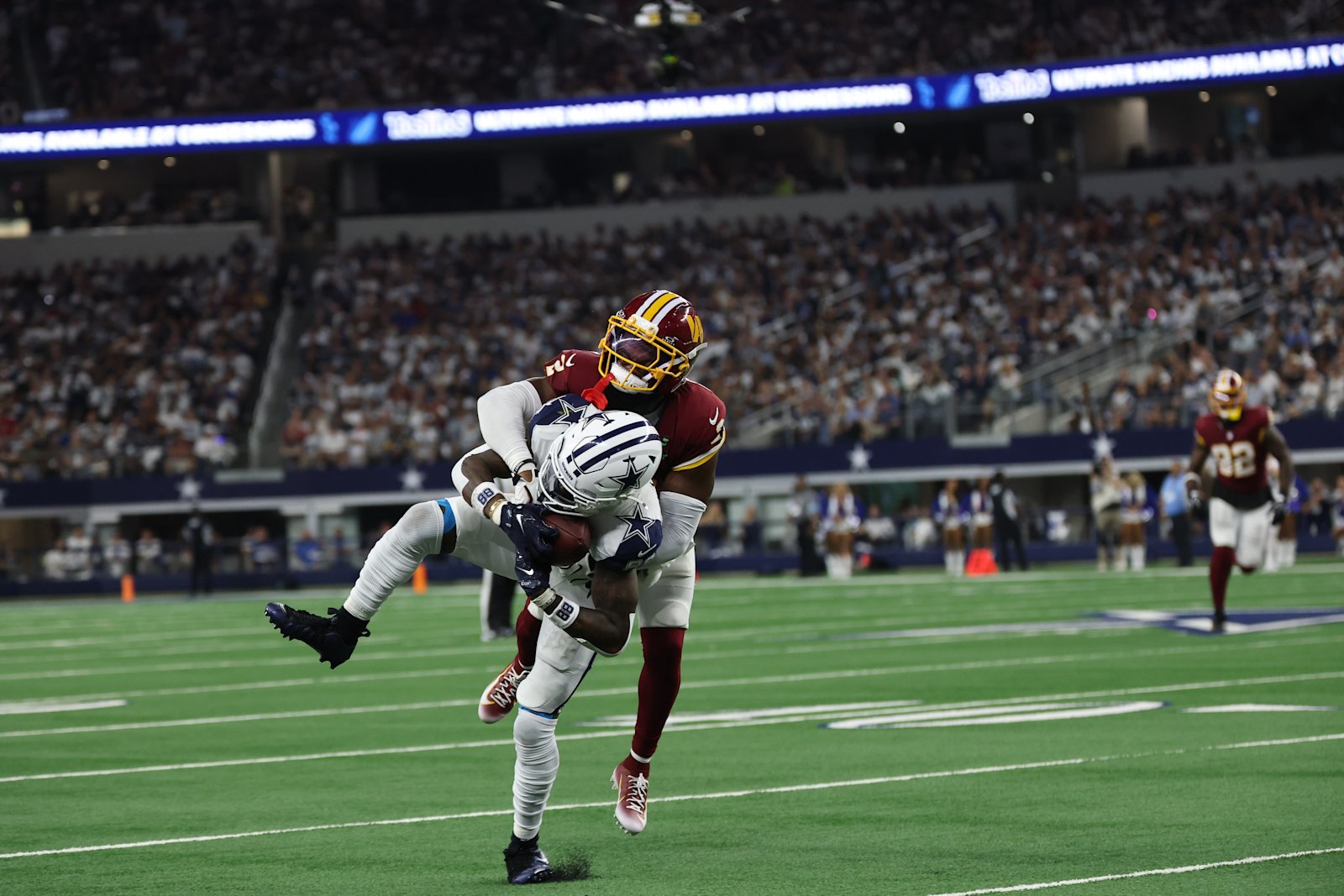 CeeDee Lamb secures the ball while being tackled by a Commanders defender in Week 2